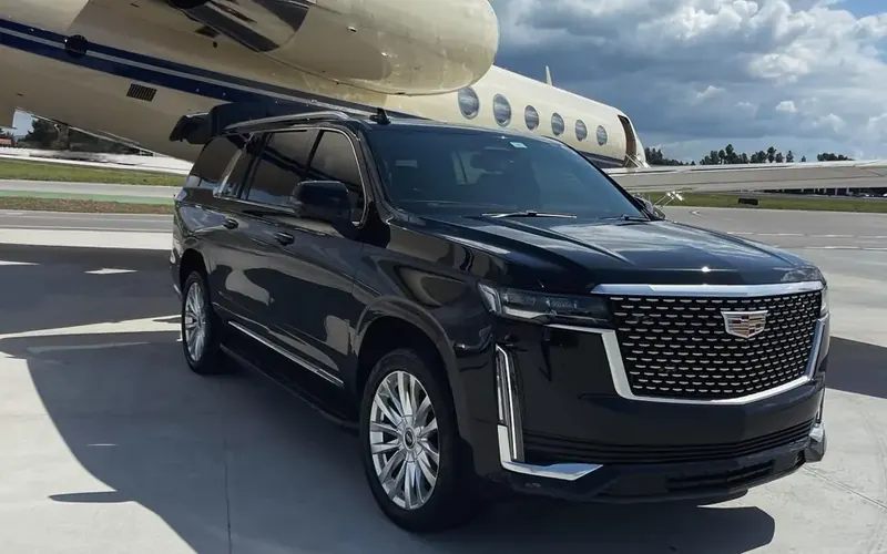 Black SUV waiting beside a private jet for an airport pickup