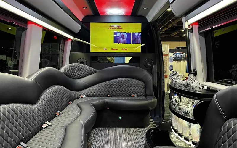 Sprinter limo interior with lounge seating and screens