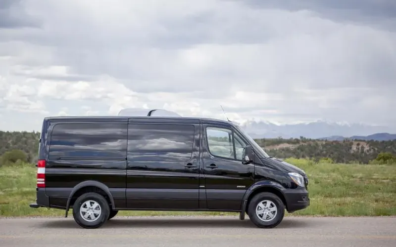 Black Mercedes Sprinter van on a countryside road